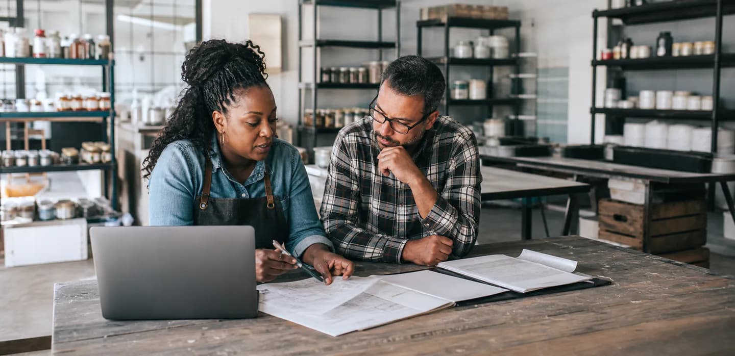A woman who owns a business reviews plans with an adviser